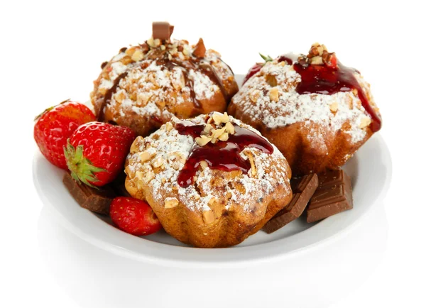 Tasty muffin cakes with strawberries and chocolate on plate, isolated on white — Stock Photo, Image