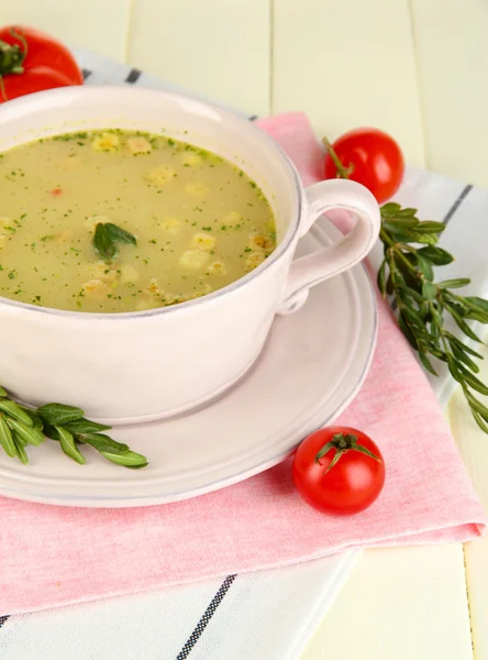 Nourishing soup in pink pan on wooden table close-up — Stock Photo, Image