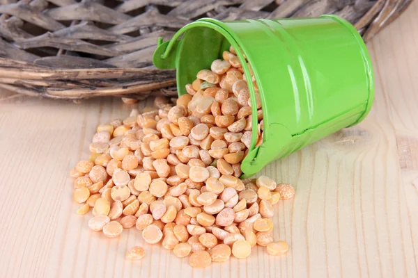 Overturned bucket with grains on wooden background — Stock Photo, Image