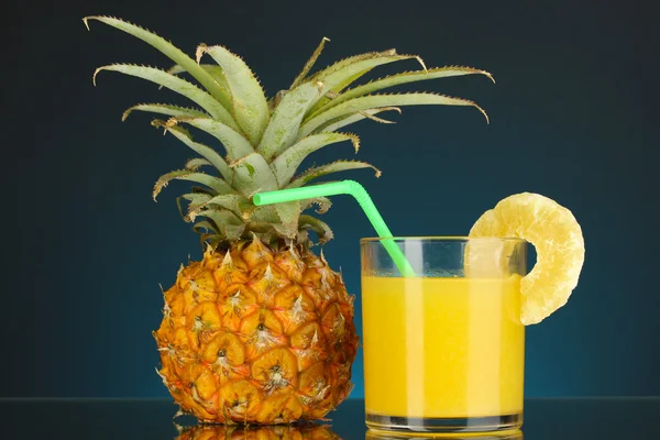 Piña madura y vaso de jugo sobre fondo azul oscuro —  Fotos de Stock