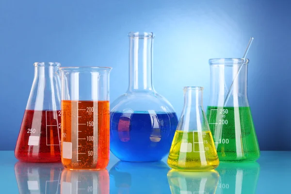 파란색 배경에 다채로운 액체와 테스트 튜브 — 스톡 사진