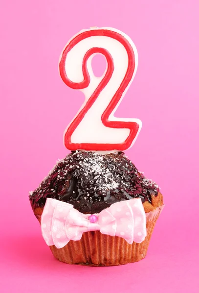 Birthday cupcake with chocolate frosting on pink background — Stock Photo, Image