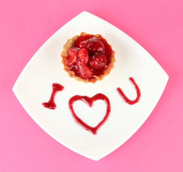 Zoete cake met aardbei en saus op plaat, op een achtergrond met kleur — Stockfoto