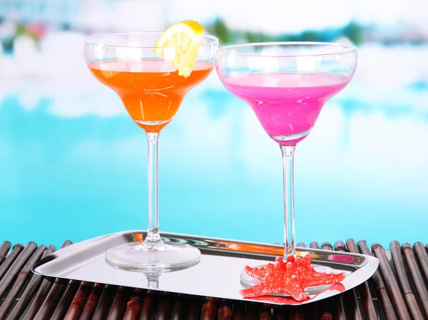 Bicchieri di cocktail sul tavolo vicino alla piscina — Foto Stock