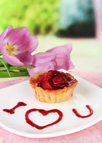 Süßer Kuchen mit Erdbeere und Soße auf Teller, mit Kaffee, auf hellem Hintergrund — Stockfoto