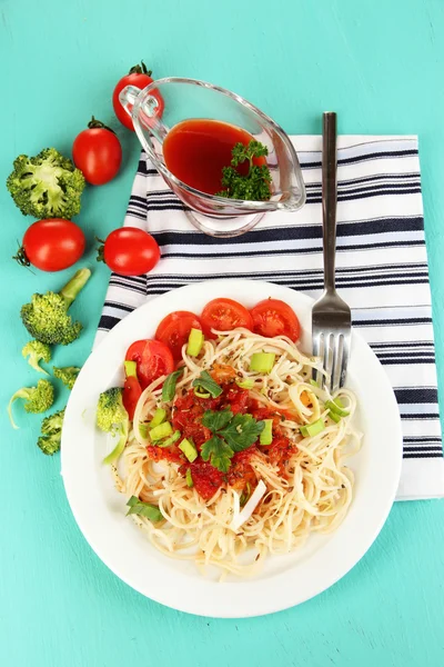 Spaghetti saporiti con salsa e verdure su piatto su tavolo di legno primo piano — Foto Stock