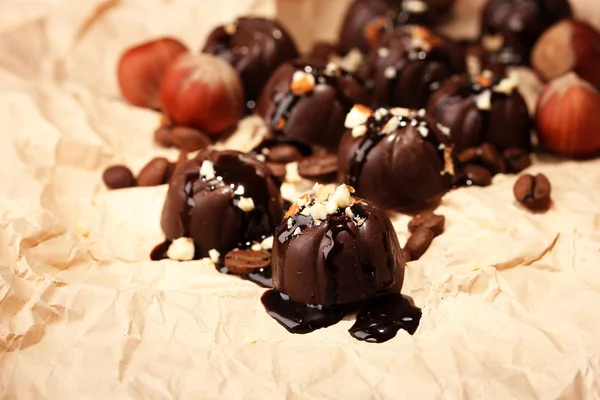 Choklad godis och kaffe bönor, på beige papper bakgrund — Stockfoto