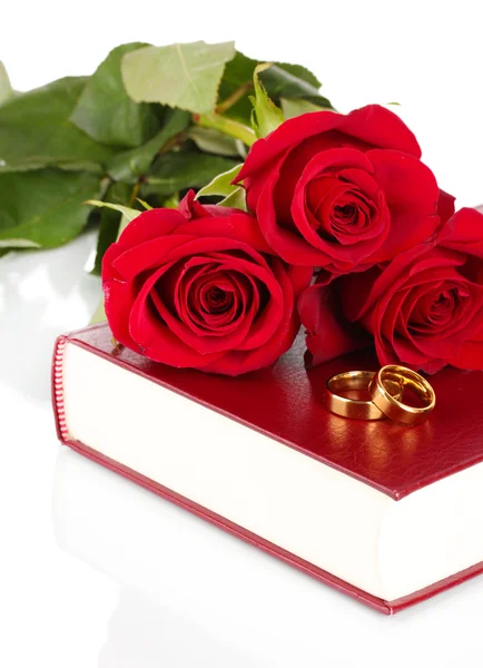 Wedding rings with roses on bible isolated on white — Stock Photo, Image