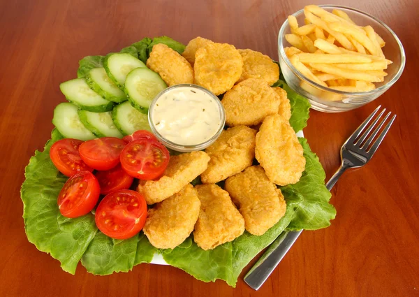 Fried chicken nuggets with vegetables,french fries and sauce on table — Stock Photo, Image