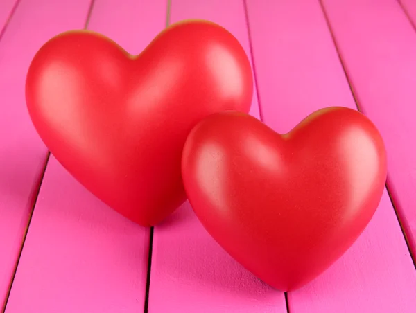 Decorative red hearts on color wooden background — Stock Photo, Image