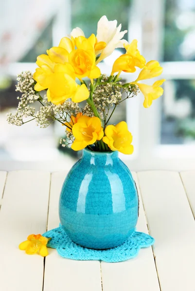 Schöner Strauß Freesien in blauer Vase auf Holztisch auf Fensterhintergrund — Stockfoto