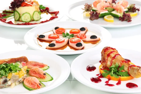 Kleine porties van voedsel op grote witte platen close-up — Stockfoto