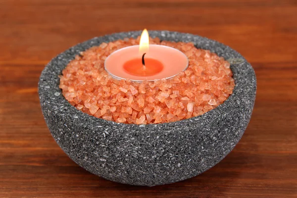 Candle in stone bowl with marine salt, on wooden background — Stock Photo, Image