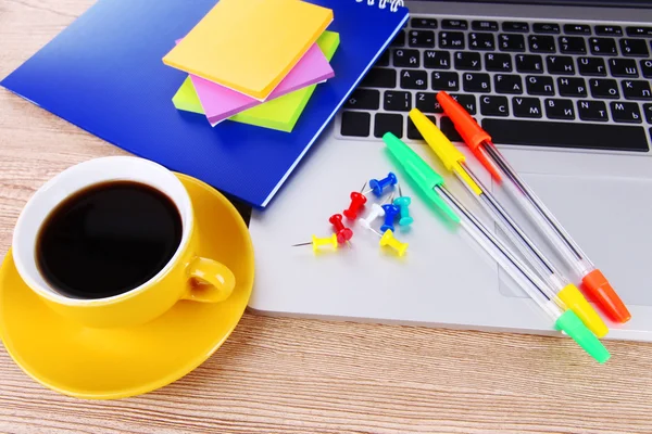 Laptop mit Schreibwaren und Tasse Kaffee auf dem Tisch — Stockfoto