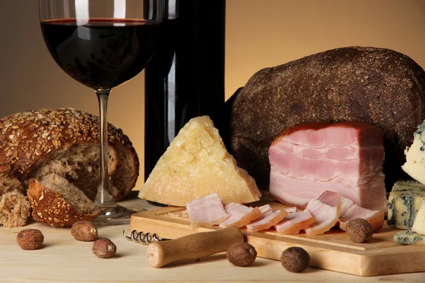 Exquisito bodegón de vino, queso y productos cárnicos — Foto de Stock