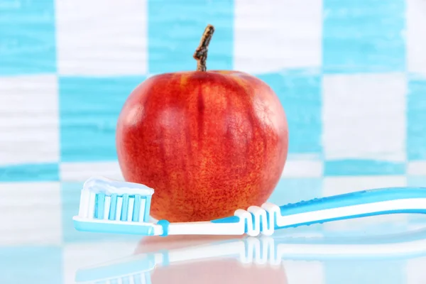 Äpple med en tandborste på hyllan i badrummet — Stockfoto