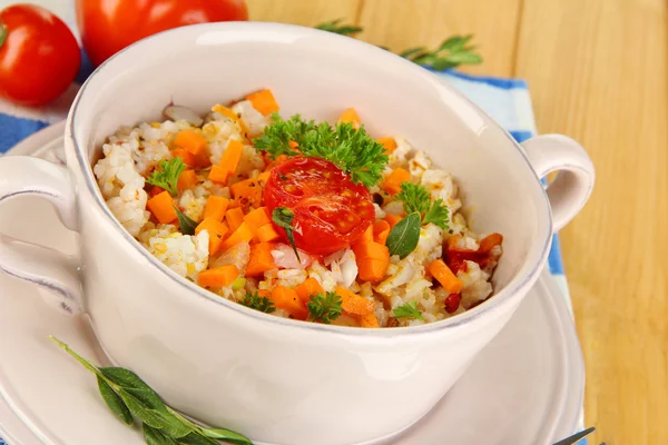 Köstlicher Reis mit Gemüse und Kräutern im Topf auf Holztisch in Großaufnahme — Stockfoto