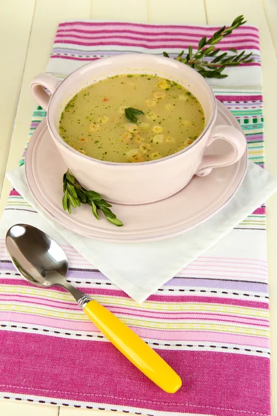 Nourishing soup in pink pan on wooden table close-up — Stock Photo, Image