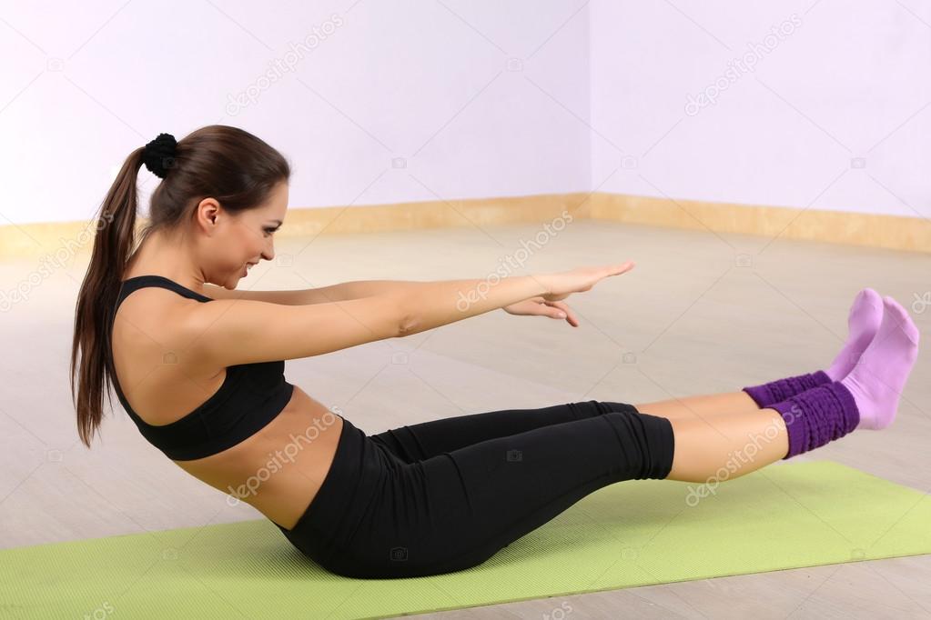 Young woman doing fitness exercises at gym
