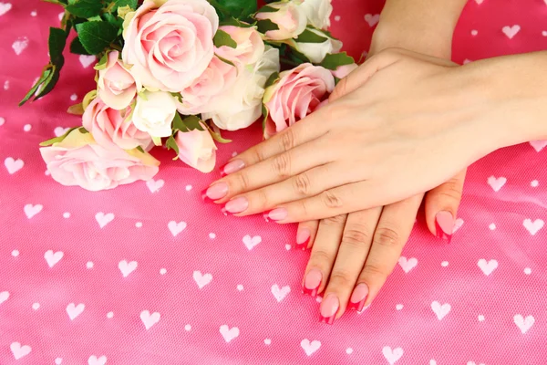 Close-up van handen van jonge vrouw met elegantie manicure, op een achtergrond met kleur — Stockfoto