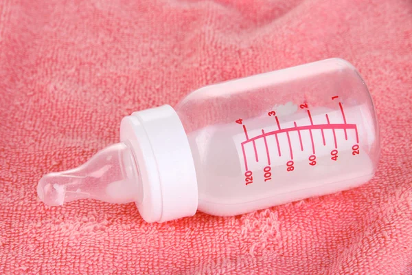 Bottiglia per latte su sfondo rosa asciugamano — Foto Stock