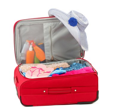 Suitcase with summer clothes, a hat and suntan isolated on white