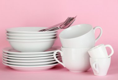 pembe bir arka plan üzerinde beyaz bulaşıkları temizle