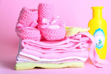 pembe bir arka plan üzerinde bebek elbise yığını