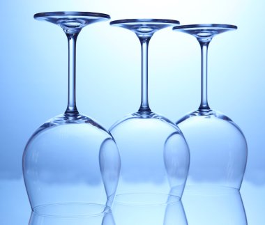 mavi zemin üzerine düzenlenen boş şarap bardakları