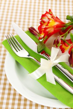 Damalı zemin üzerine çiçekli şenlikli yemek masası ayarı