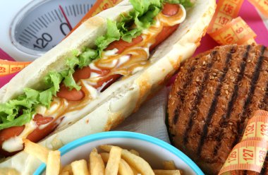 Sosisli, hamburger ve patates üzerinde ölçekler yakın çekim