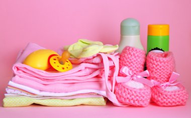 pembe bir arka plan üzerinde bebek elbise yığını