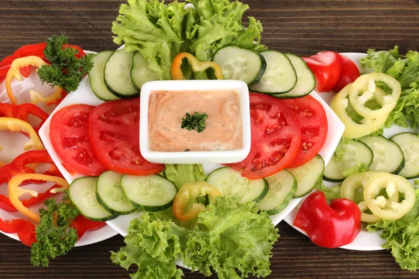 Verdure tritate e salsa sul piatto sul tavolo di legno — Foto Stock
