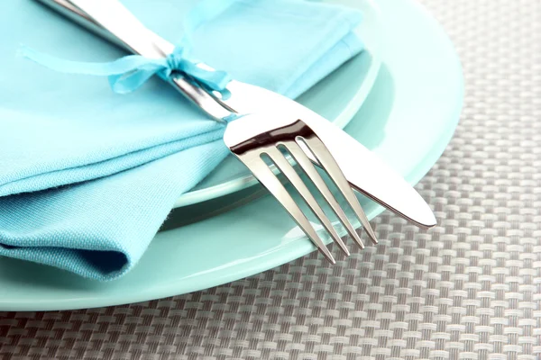 Placas azuis vazias com garfo e faca em uma toalha de mesa cinza — Fotografia de Stock