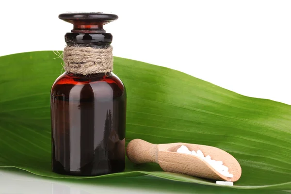 Frasco de medicamento con comprimidos en hoja verde aislados en blanco —  Fotos de Stock