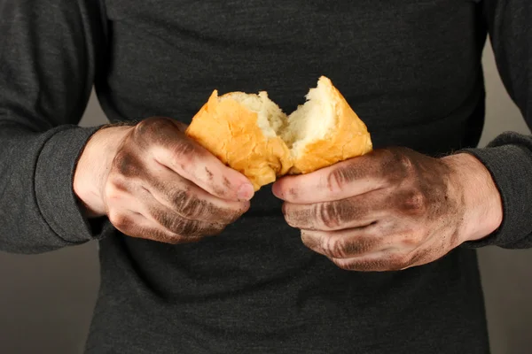 Senzatetto con in mano un pane bianco, primo piano — Foto Stock