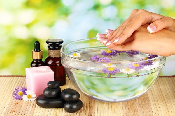 Tratamientos de spa para las manos femeninas, sobre fondo verde brillante — Foto de Stock