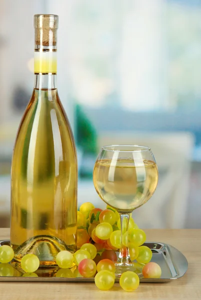 Vitt vin i glas med flaska på salver på rummet bakgrund — Stockfoto