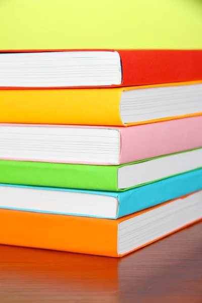 Stapel multicolor boeken op groene achtergrond — Stockfoto