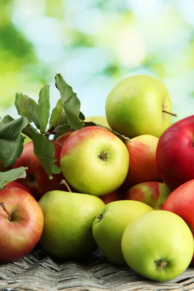 Manzanas jugosas con hojas, sobre fondo verde —  Fotos de Stock