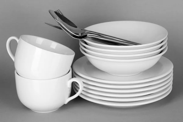 Чистий білий посуд на сірому фоні — стокове фото
