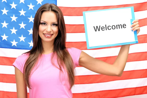 Fiatal nő fiatal nő gazdaság tabletta a háttérben, az amerikai zászló — Stock Fotó