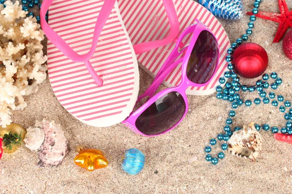 Bolas de Navidad, conchas marinas y accesorios de playa en la arena, primer plano — Foto de Stock