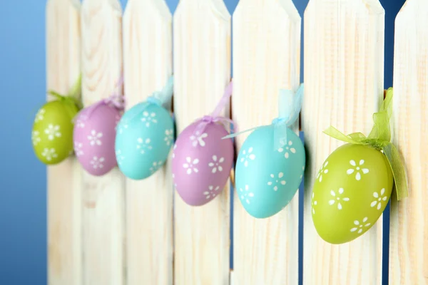 Art Easter background with eggs hanging on fence — Stock Photo, Image