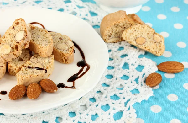 Galletas aromáticas cantuccini en plato con taza de café sobre mantel azul primer plano —  Fotos de Stock