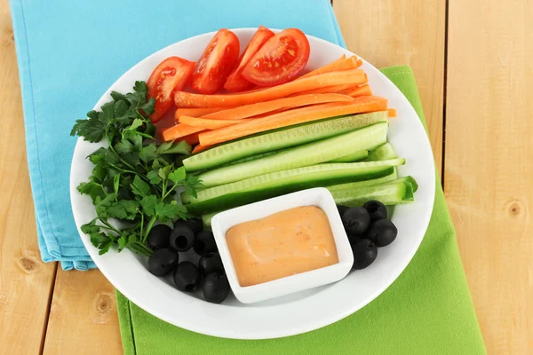 Assorted raw vegetables sticks in plate on wooden table close up — Stock Photo, Image