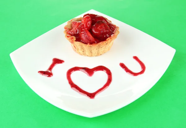 Gâteau sucré aux fraises et sauce sur assiette, sur fond de couleur — Photo