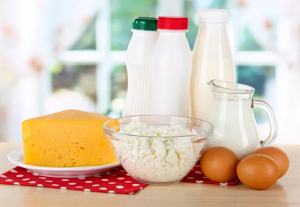 Молочные продукты и яйца на салфетке на столе на кухне — стоковое фото