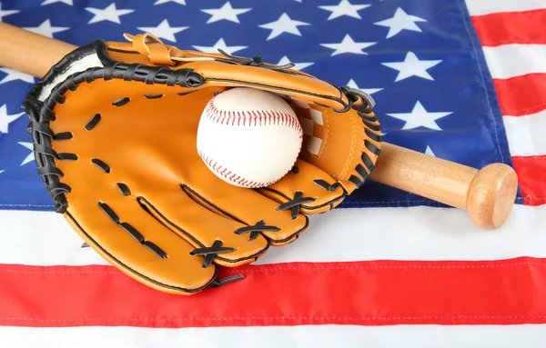 Guante de béisbol, bate y pelota sobre fondo de bandera estadounidense — Foto de Stock