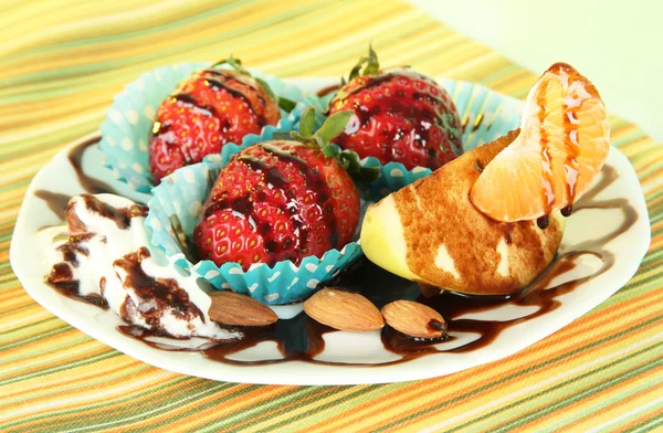 Fruit in chocolade op plaat op tafellaken close-up — Stockfoto